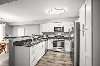 Kitchen with white cabinets and dark granite countertops